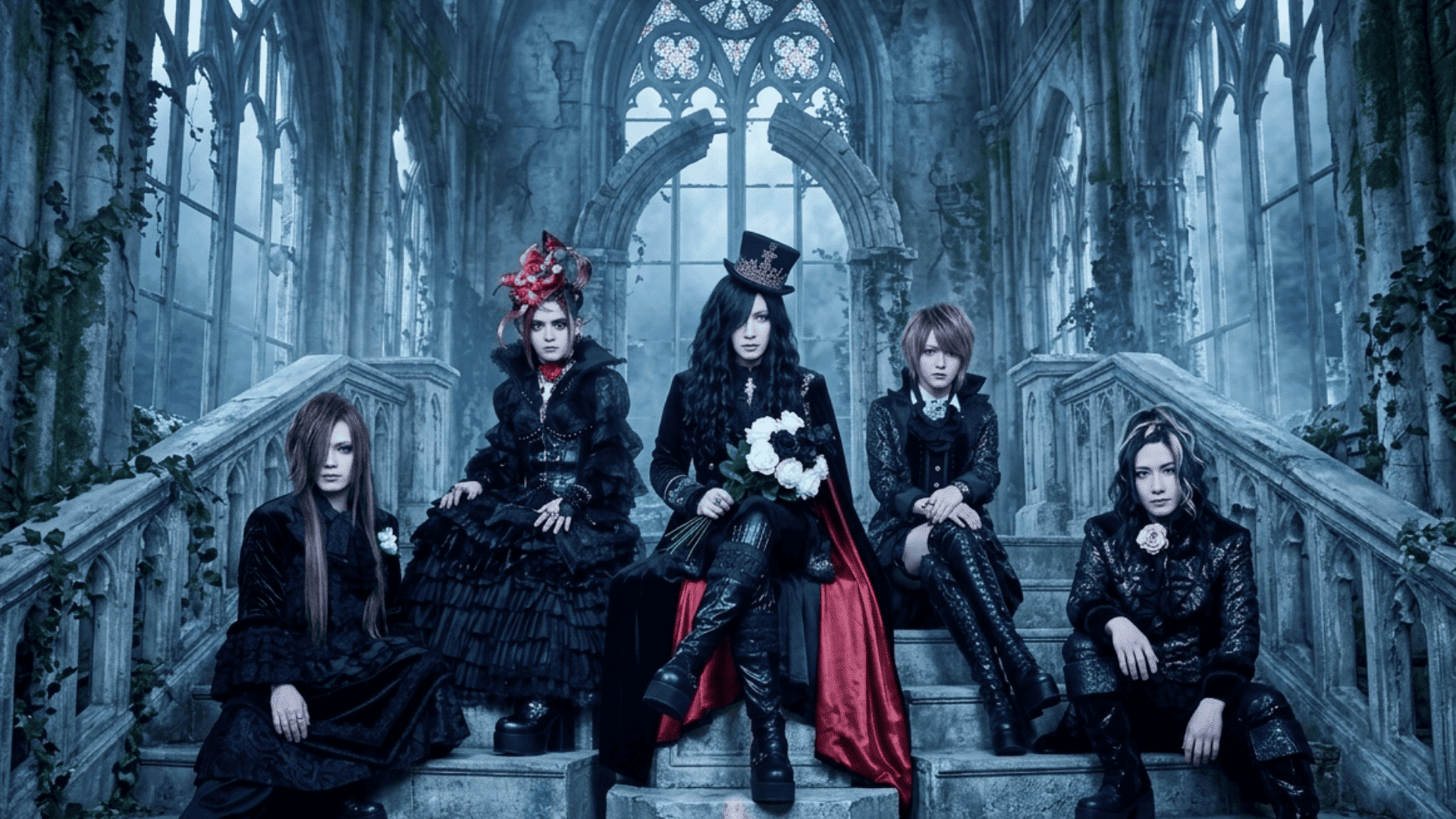 A Japanese gothic band poses on stone steps within an ivy-covered ruined cathedral with stained glass and a fire cauldron