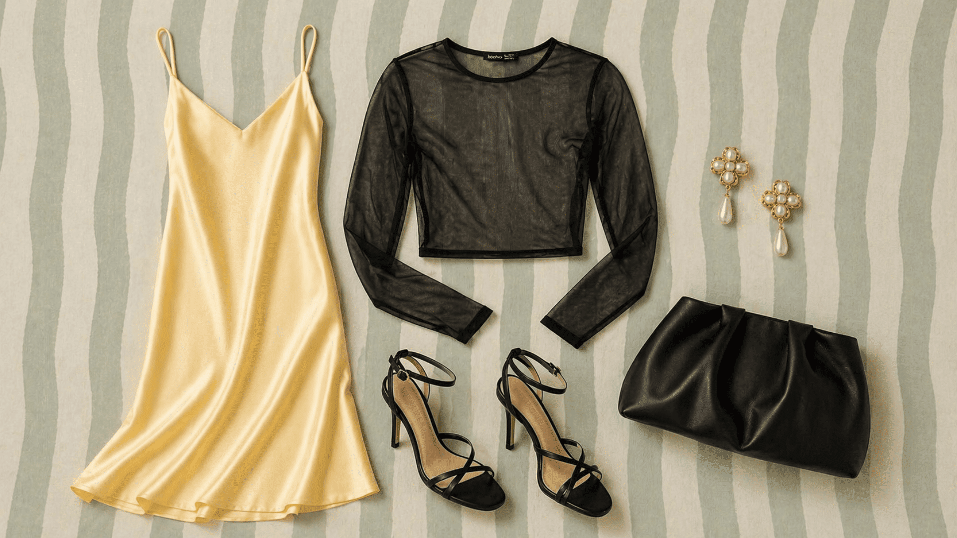 Flat lay with yellow slip dress, black heels, clutch bag, sheer top, pearl earrings on a soft green striped background