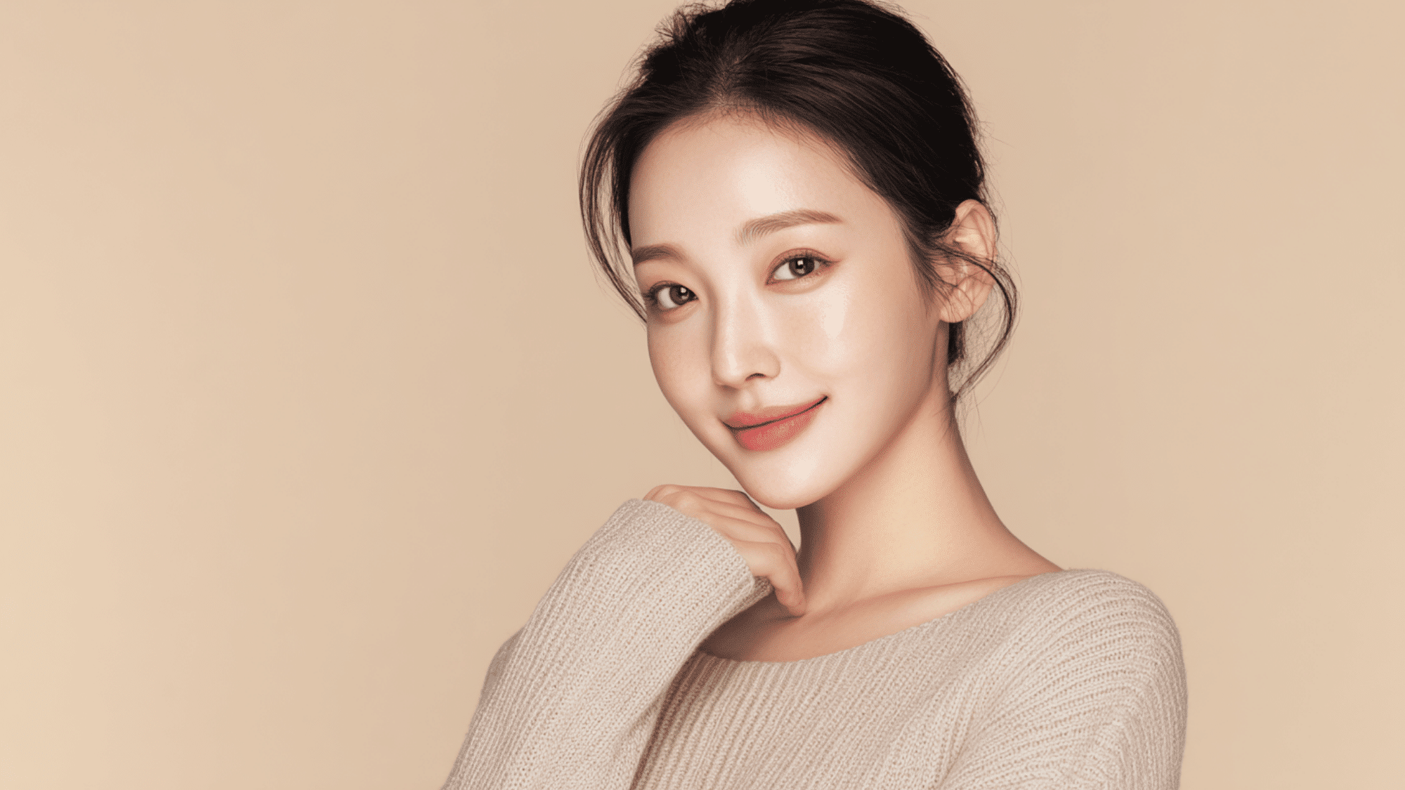 portrait of smiling woman with clear glowing skin natural makeup and soft neutral background beauty shot