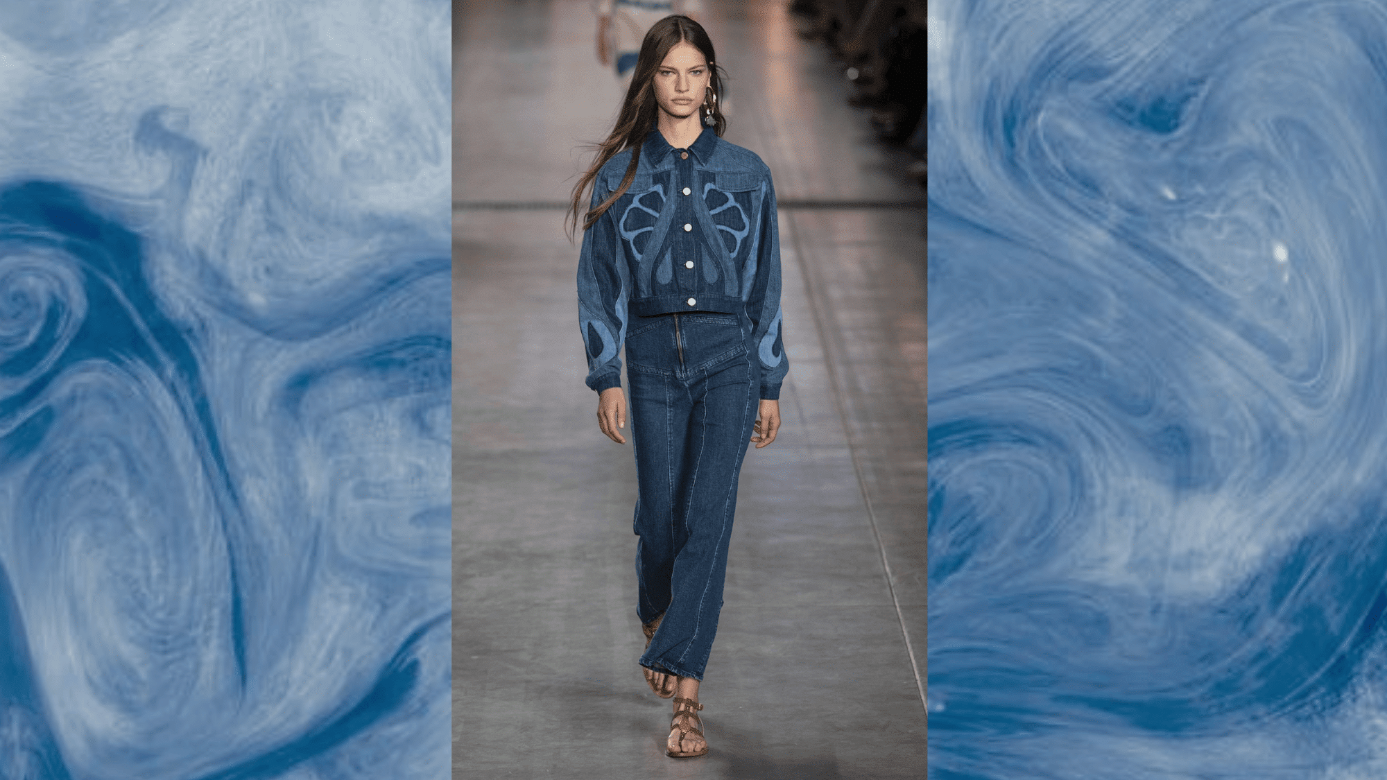 runway model in denim-on-denim look, embroidered jacket with dark bootcut jeans and flat sandals