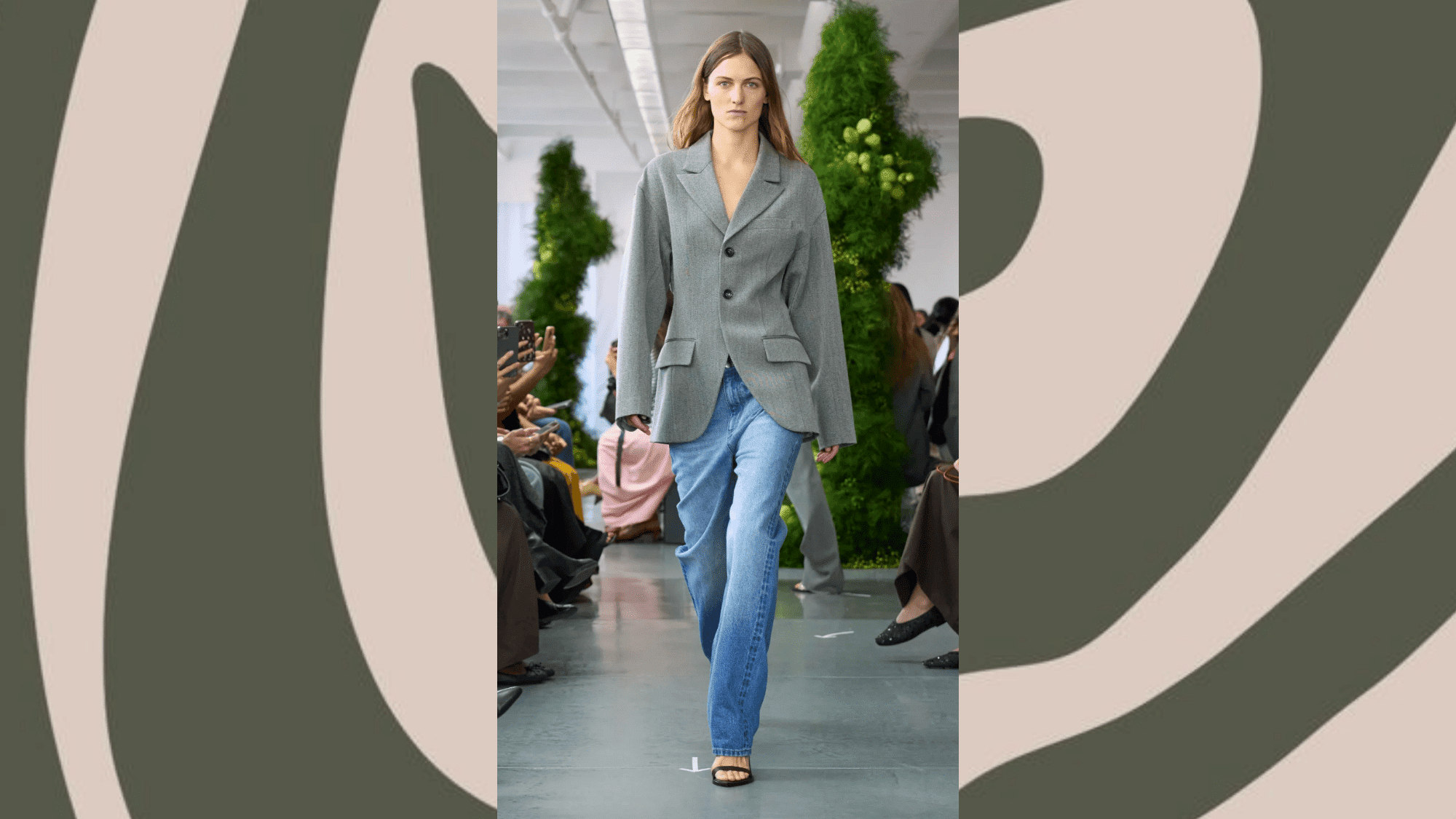 _runway model in oversized grey blazer with light wash bootcut jeans and black strappy sandals