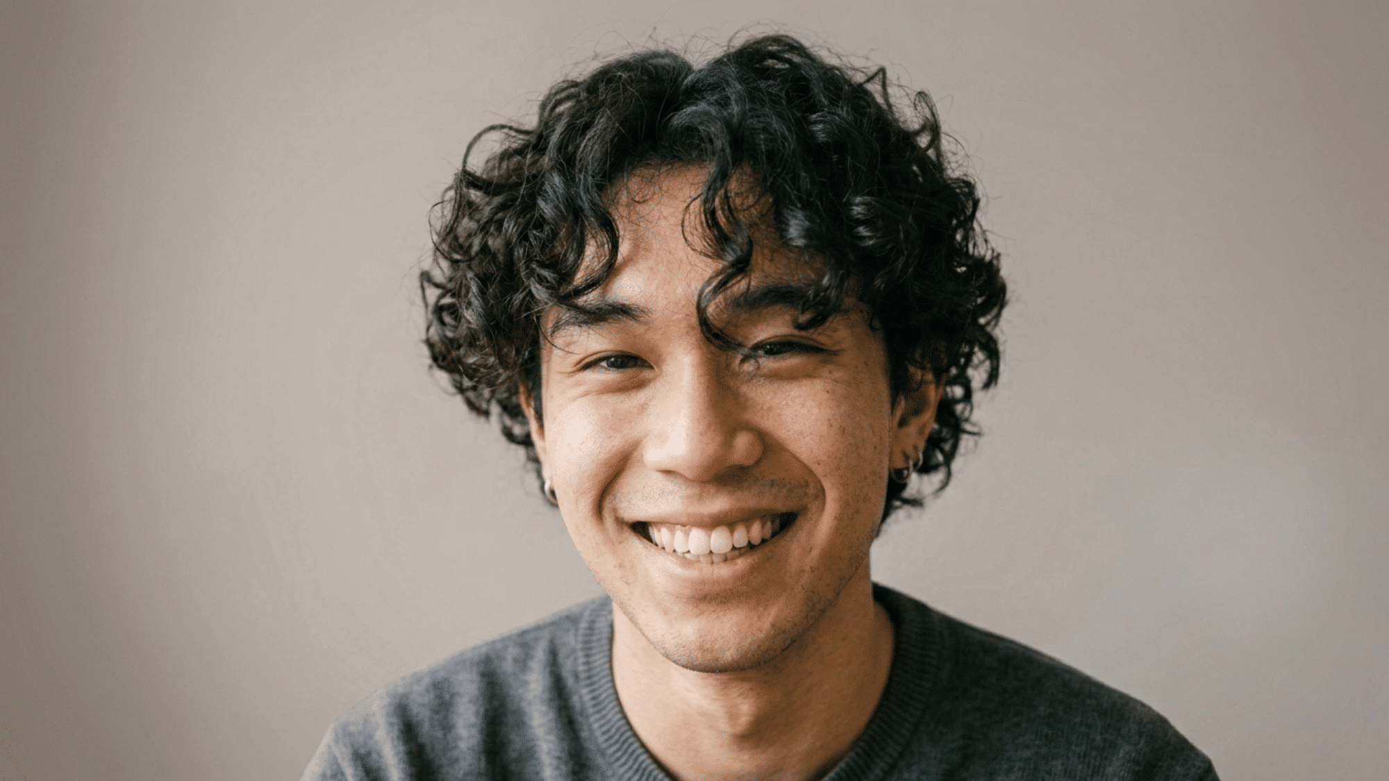 smiling man with soft curly fringe across forehead