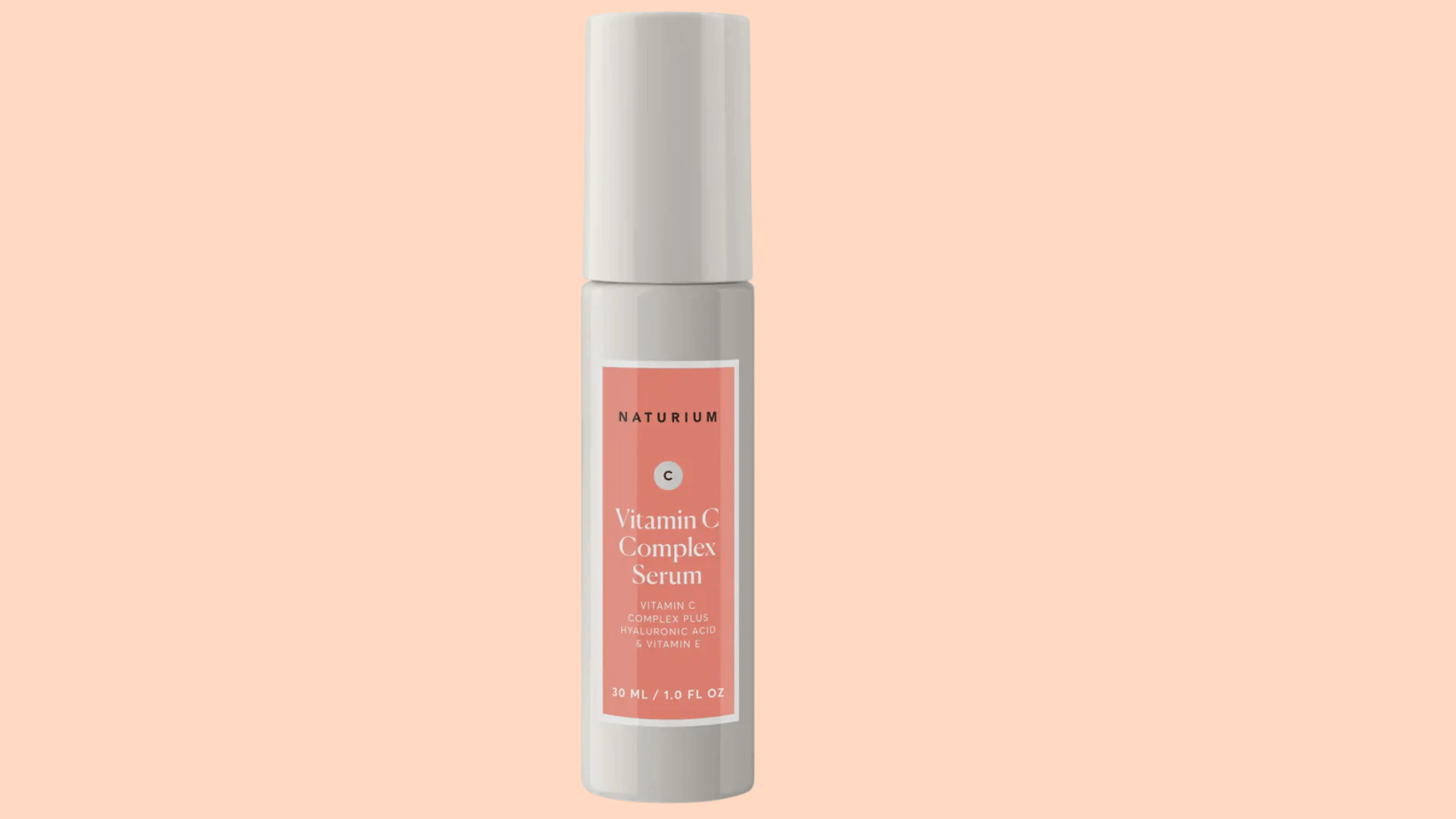 naturium vitamin c complex serum bottle with hyaluronic acid and vitamin c displayed against a soft peach background