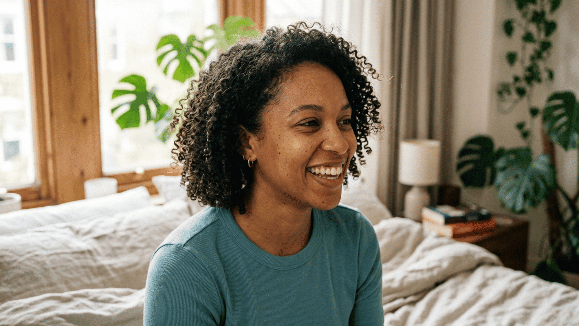 woman smiling with short defined natural 3c curls indoors